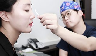 의사가 환자 코에 자를 대고 디자인하는 모습