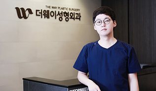로고 간판 앞 안내데스크에 선 의사